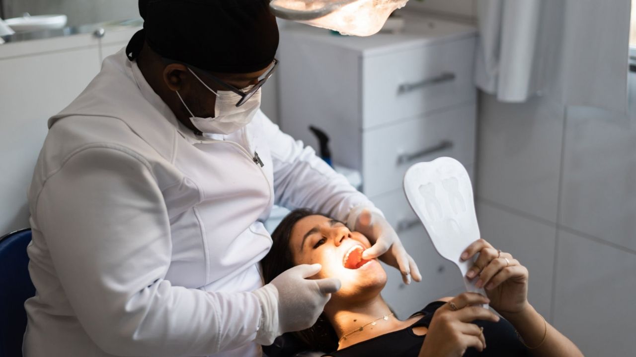 Dentista avaliando arcada dentária de paciente