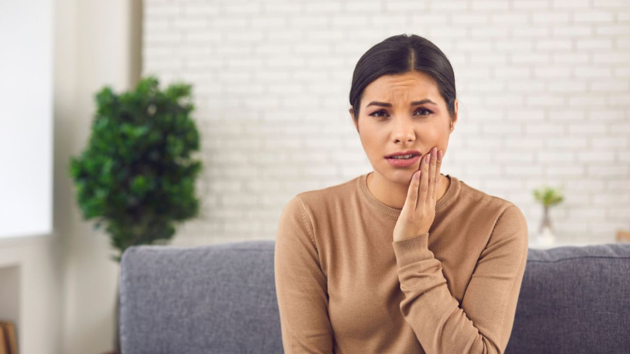 mulher pensando se dente siso inflamado pode ser extraído