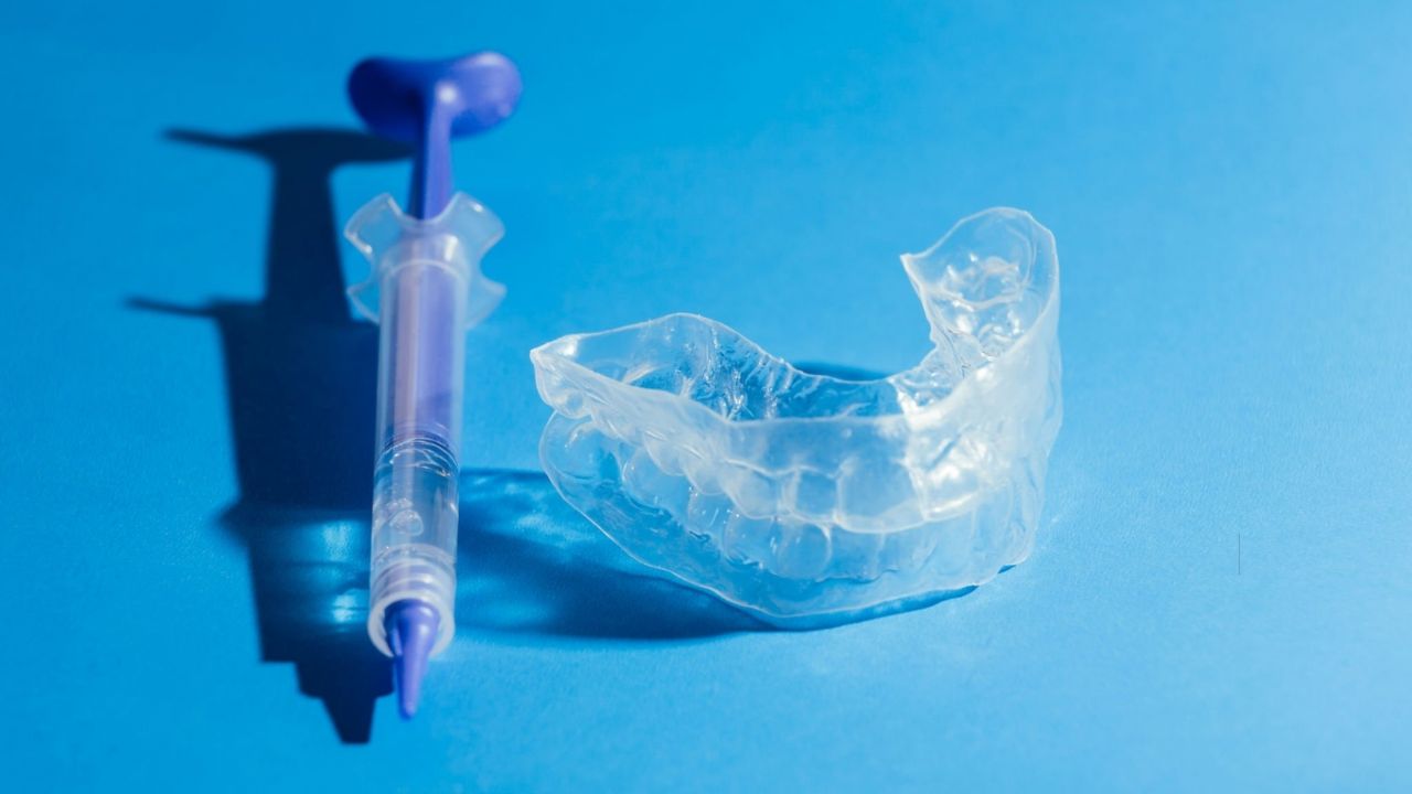 Instrumentos utilizados para o clareamento caseiro dental sobre fundo azul