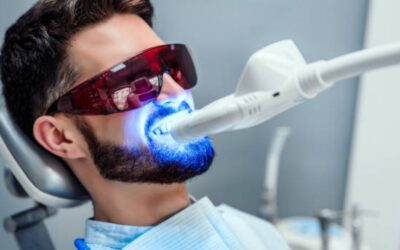 Homem passando pelo tratamento de clareamento dental a laser em consultório odontológico