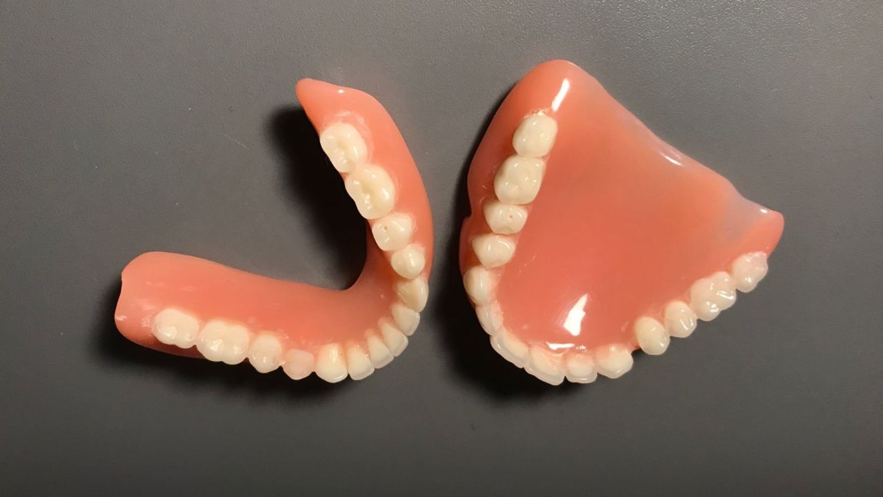 Prótese de silicone dentária sobre superfície cinza