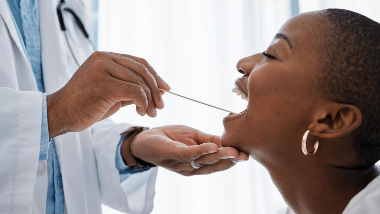 paciente realizando um exame para procurar indícios de câncer de boca