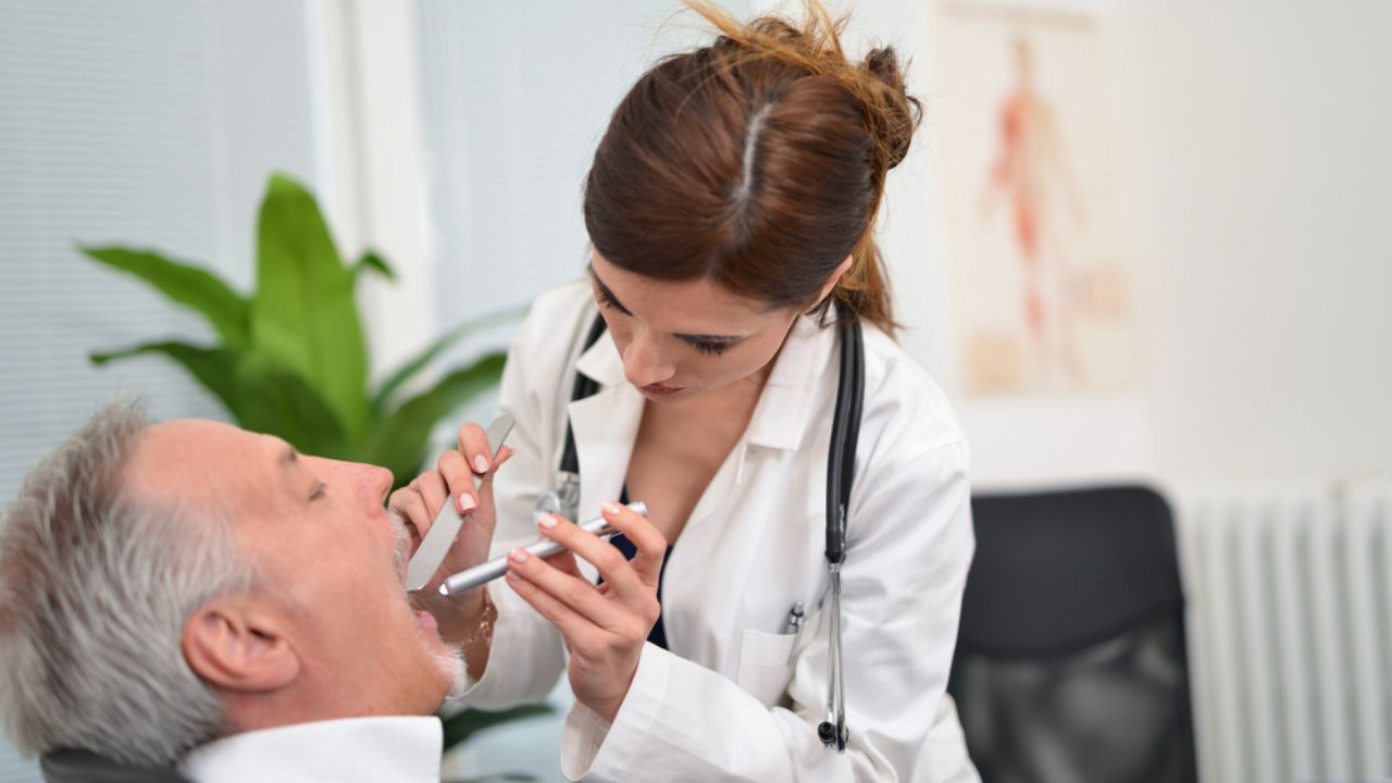 médico avaliando o desenvolvimento do câncer de boca do paciente