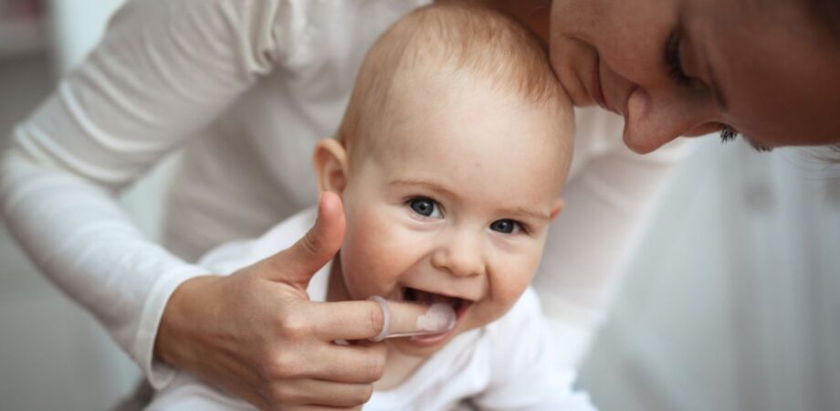 mãe mostrando como limpar a língua do bebê