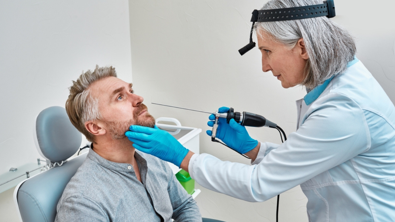 Uma médica realizando uma nasofibroscopia, ou endoscopia nasal, exame para detectar HPV na garganta.