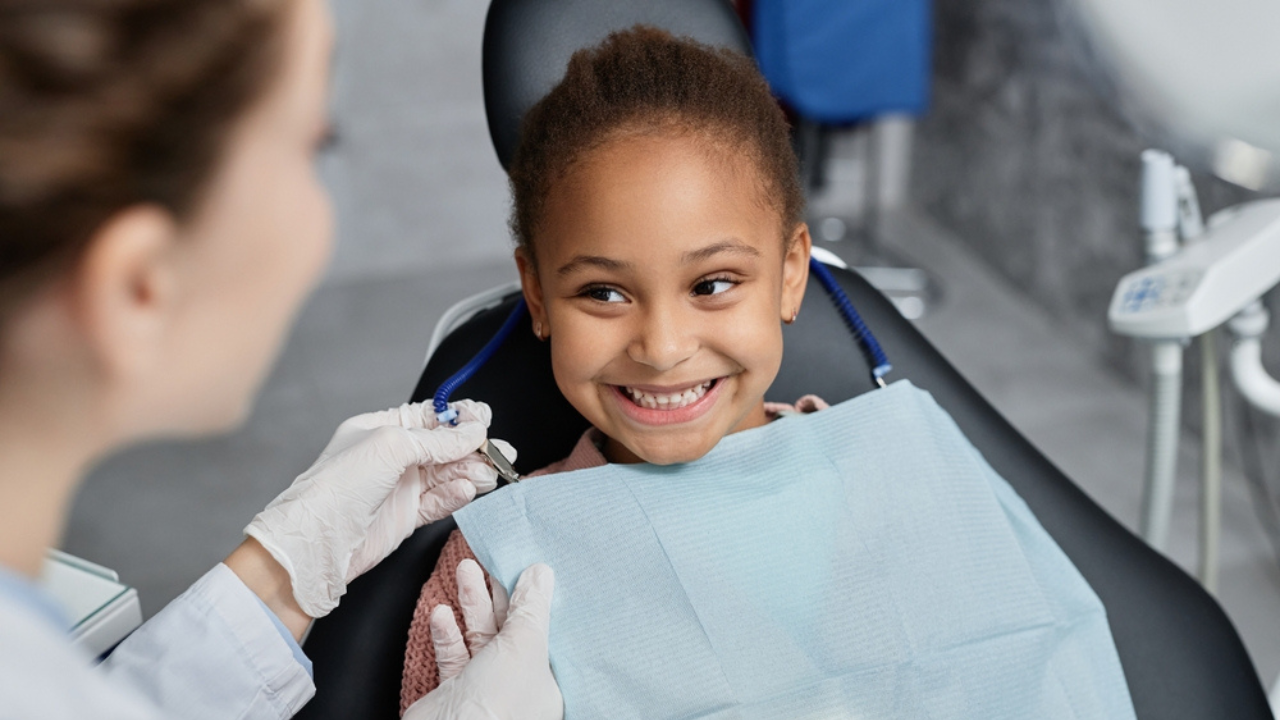 Uma criança sorridente após a realização de pulpotomia em dentes deciduos.